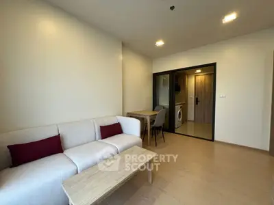 Modern living room with cozy sofa and dining area in open layout apartment.