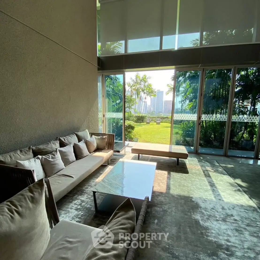 Luxurious living room with floor-to-ceiling windows and garden view.