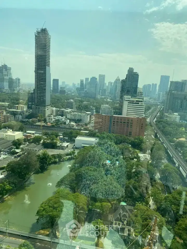 Stunning cityscape view from high-rise building with lush greenery and skyline.