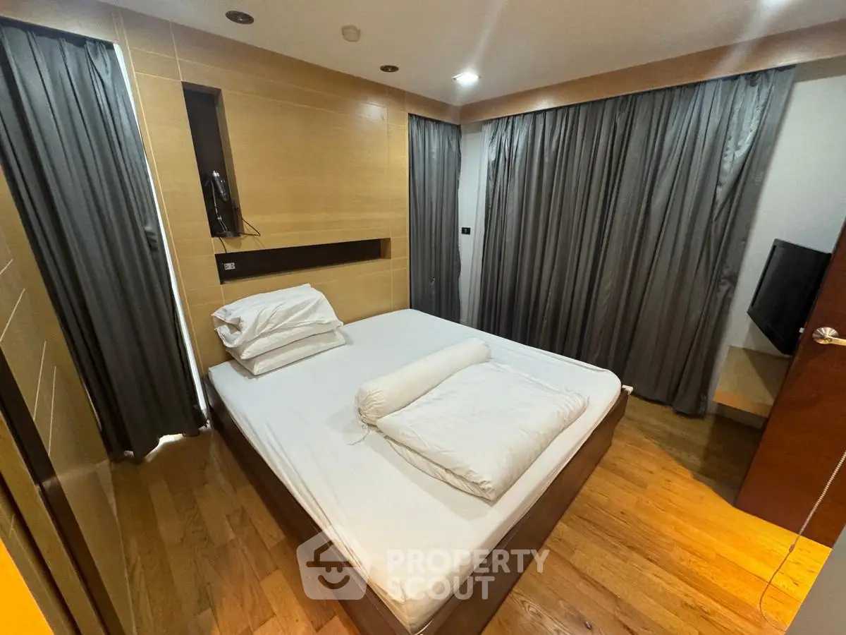 Cozy modern bedroom with wooden flooring and elegant curtains