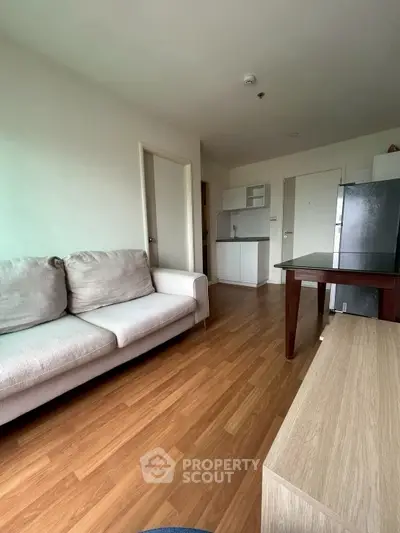 Modern living room with wooden flooring and cozy beige sofa