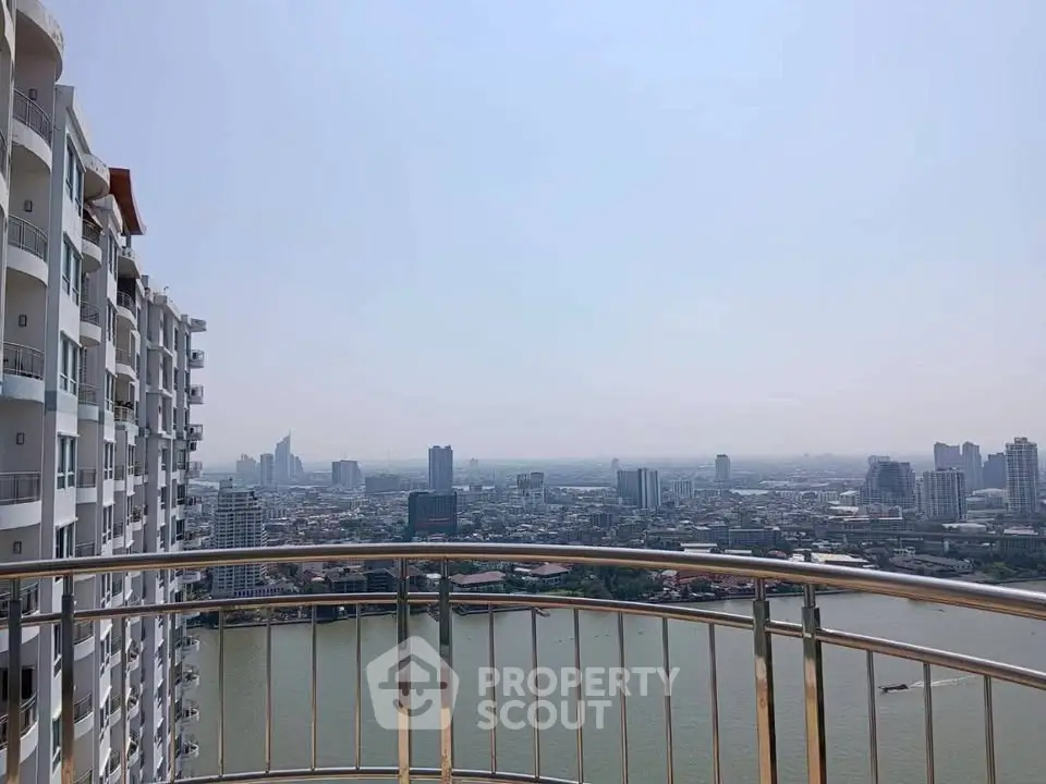 Stunning high-rise balcony view overlooking a vibrant cityscape and river.