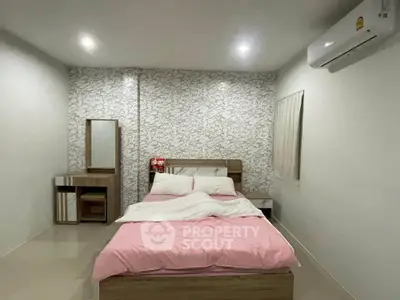 Spacious bedroom with modern decor and air conditioning, featuring a comfortable bed and stylish furniture.