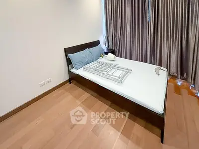 Spacious bedroom with wooden flooring and modern bed frame, ideal for comfort and relaxation.