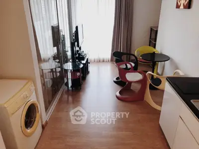 Modern living room with stylish chairs and washing machine, featuring floor-to-ceiling windows for natural light.