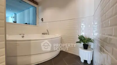 Spacious bathroom with corner bathtub and modern tile design