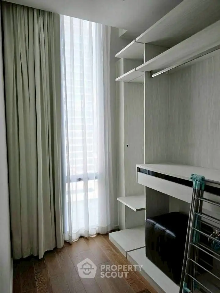 Modern storage space with natural light and sleek shelving in a contemporary apartment.