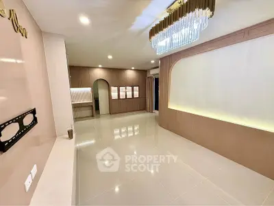 Spacious modern living room with elegant chandelier and built-in storage