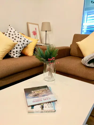 Cozy living room with stylish brown sofa, decorative pillows, and modern coffee table.
