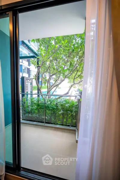 Charming balcony view with lush greenery and poolside ambiance, perfect for relaxation and outdoor enjoyment.