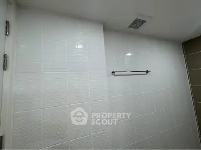 Modern bathroom with sleek white tiles and towel rack