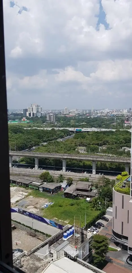 Stunning cityscape view from high-rise building window showcasing urban landscape and greenery.