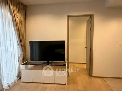 Modern living room with sleek TV stand and large window with curtains