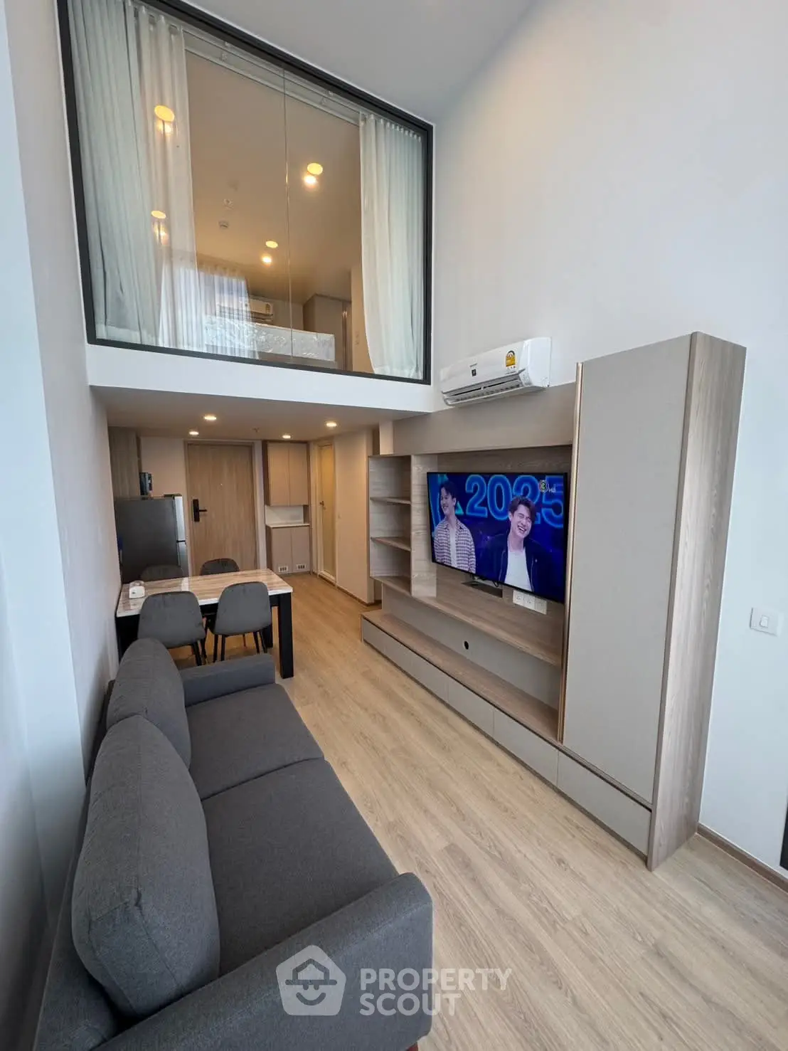 Modern loft-style living room with mezzanine bedroom and sleek furnishings
