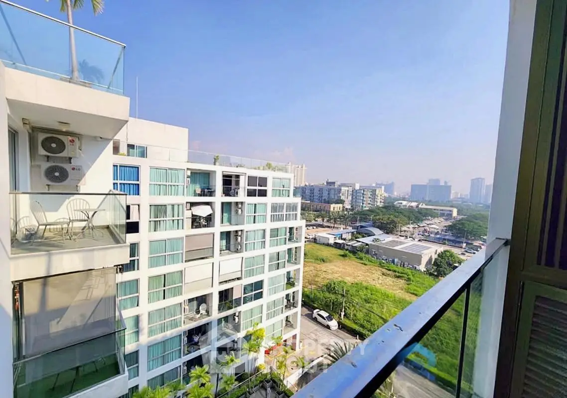 Stunning cityscape view from modern apartment balcony with glass railing.