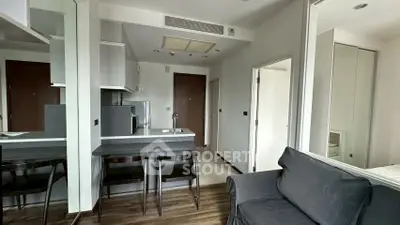 Modern apartment interior with sleek kitchen and cozy living area, featuring contemporary design and efficient layout.