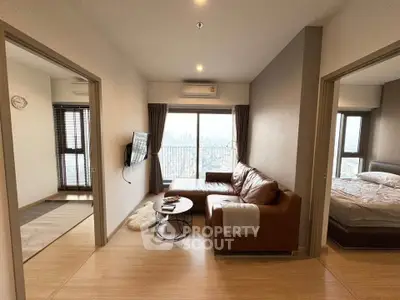 Modern apartment living room with city view, leather sofa, and wall-mounted TV