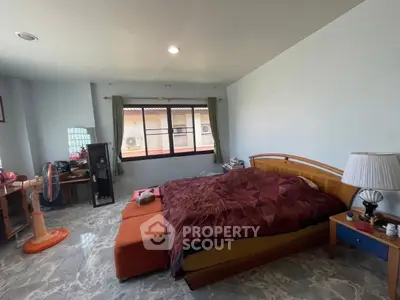 Spacious bedroom with cozy bed and natural light from large window