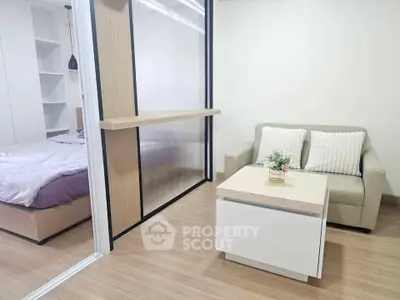 Modern studio apartment with cozy living area and sliding partition for bedroom privacy.