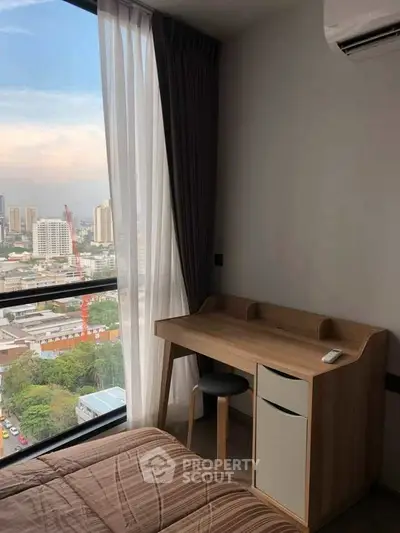 Cozy bedroom with city view and study desk, perfect for urban living.