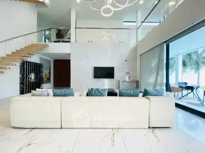 Luxurious modern living room with elegant staircase and floor-to-ceiling windows