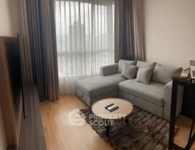 Modern living room with cozy gray sectional sofa and large window with city view.