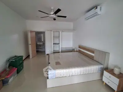 Spacious bedroom with modern furniture and air conditioning, ideal for comfort and relaxation.