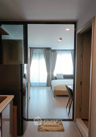 Modern studio apartment with open layout, featuring a cozy bedroom and sleek kitchen area.