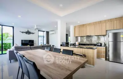 Modern open-plan living room and kitchen with sleek design and natural light.