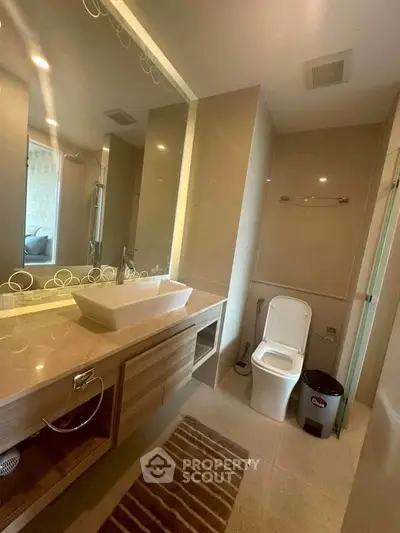 Modern bathroom with sleek fixtures and large mirror in a contemporary home.