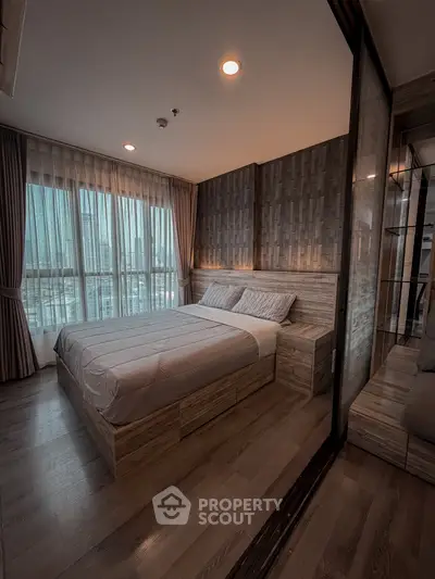 Modern bedroom with stylish decor and large windows offering city views.