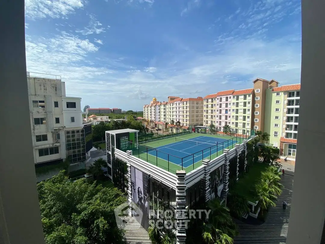 Stunning view of residential complex with tennis court and lush greenery