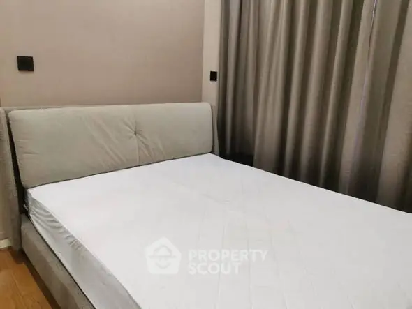 Cozy bedroom with modern design and neutral tones, featuring a comfortable bed and elegant curtains.