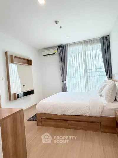Modern bedroom with large window and wooden furniture in a stylish apartment.