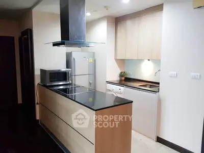 Modern kitchen with sleek appliances and wooden cabinetry in a stylish apartment.