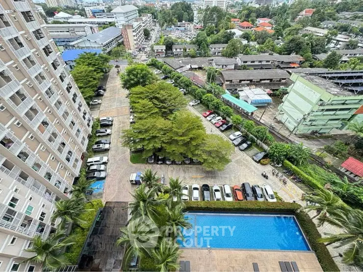 Stunning aerial view of residential complex with pool and lush greenery, perfect for urban living.
