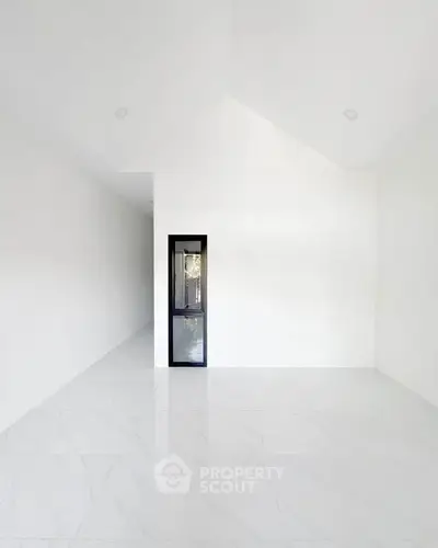 Spacious minimalist interior with high ceilings and sleek design, perfect for modern living.