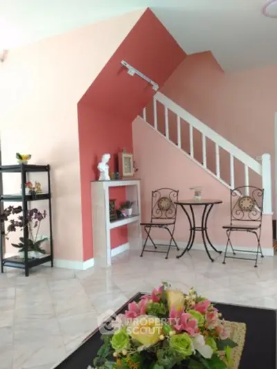 Charming living room with elegant staircase and floral decor