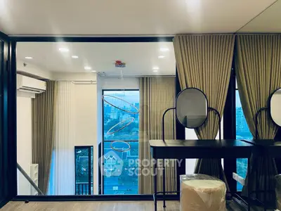 Modern living room with large windows and elegant curtains offering a stunning city view.