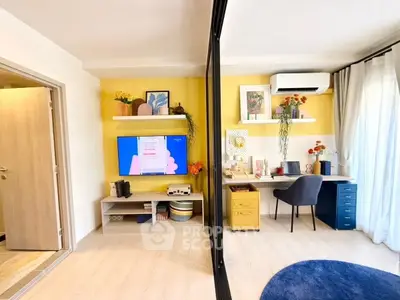 Stylish modern living room with vibrant decor and workspace, featuring a TV and air conditioning.