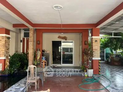 Charming covered patio with rustic decor and garden view, perfect for outdoor relaxation.