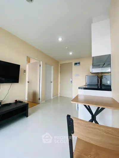 Modern apartment interior with sleek kitchen and cozy living area, perfect for urban living.