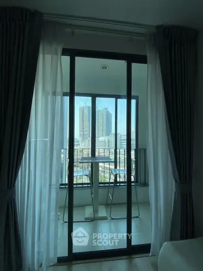 Modern apartment with floor-to-ceiling windows and city view from balcony.