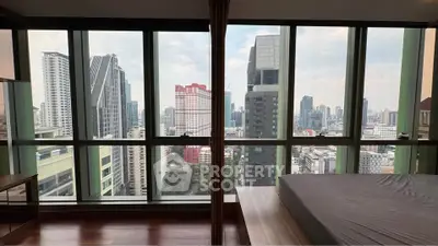 Stunning high-rise bedroom with panoramic city views and floor-to-ceiling windows.
