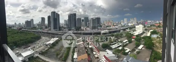 Stunning cityscape view from high-rise balcony overlooking urban skyline and highway.