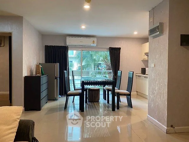 Spacious open-plan living and dining area with modern furnishings and large window view.