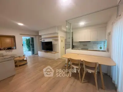 Spacious open-plan living room with modern kitchen and stylish wooden flooring.