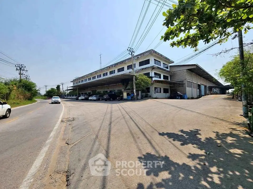 Spacious industrial building with ample parking and easy road access, perfect for business operations.