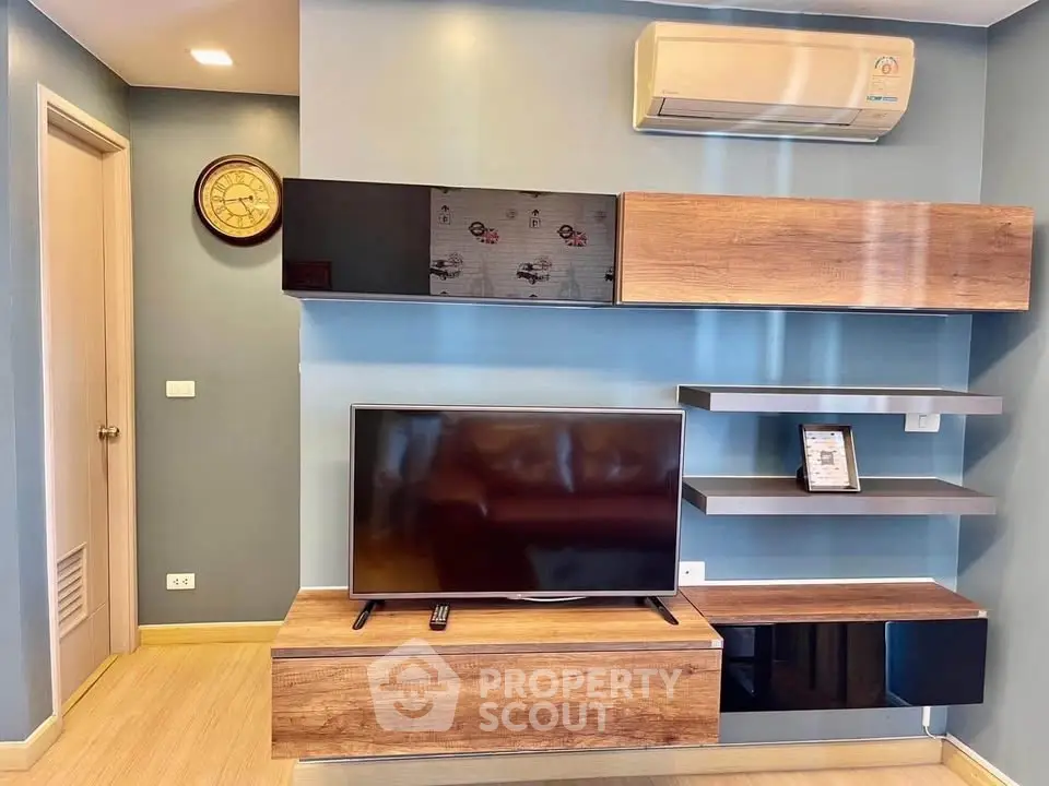 Modern living room with stylish shelving and wall-mounted TV, featuring sleek air conditioning unit.