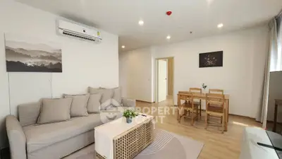 Modern living room with cozy sofa and dining area in open layout apartment.